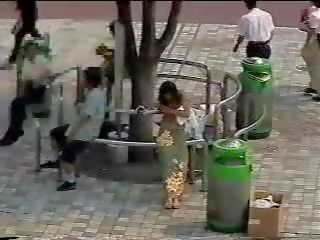 Skiftande i den gata - japanska ung lady i offentlig först delen